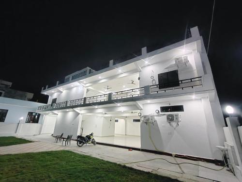 a white building with a motorcycle parked in front of it at ANAND BHAWAN i in Shivāpur