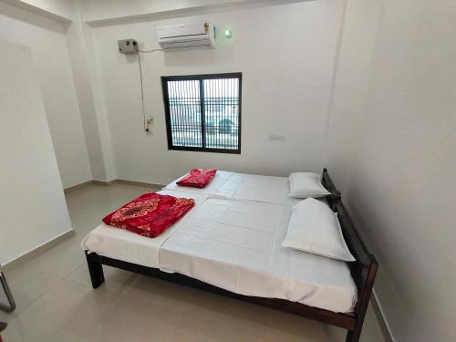 a bedroom with a bed with red pillows on it at ANAND BHAWAN i in Shivāpur