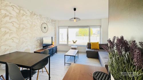 un salon avec un canapé et une table dans l'établissement Appartement Sunrise au pied de la plage, à Merlimont