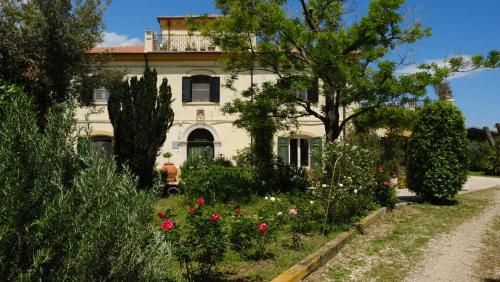 a white house with flowers in front of it at Colonna Country Home in Ururi