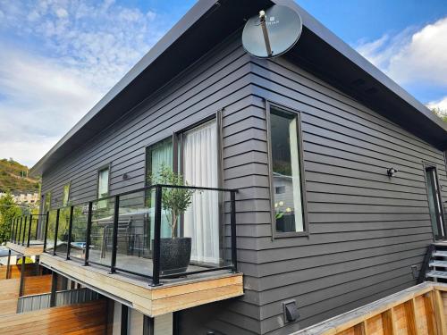 a house with a deck with a potted plant on it at Apartment in the Heart of Queenstown in Queenstown