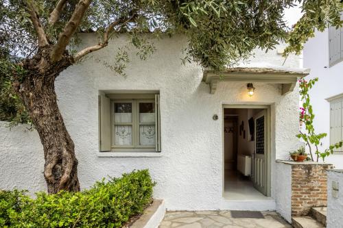 a white house with a tree in front of it at Archodiko at Palio Klima in Neo Klima