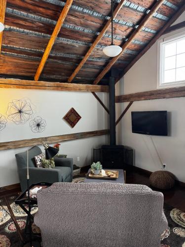 a living room with a couch and a tv at The Farm Shed Guelph Elora in Guelph