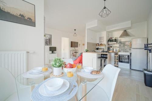 une cuisine et une salle à manger avec une table et des chaises dans l'établissement Parking, balcon, vue jardin à 5 minutes du metro, à Saint-Ouen