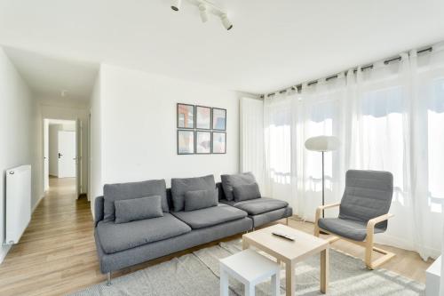 un salon avec un canapé et deux chaises dans l'établissement GuestReady - Bright Escape with City Views, à Bobigny