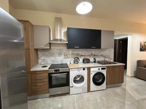 a kitchen with a stove and a washer and dryer at Ta' Landar Holiday Lets in Żabbar