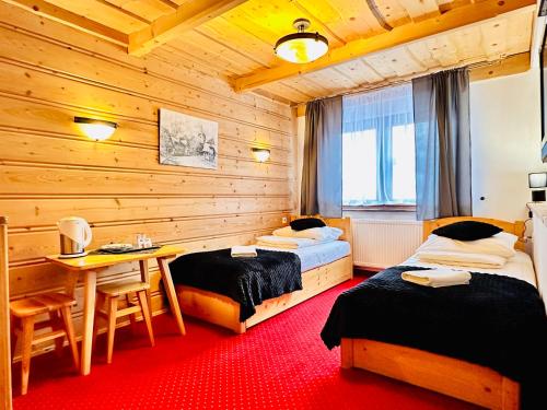 una camera da letto con due letti, un tavolo e una scrivania di Willa u podnóża Tatr Cztery Pory Roku a Kościelisko