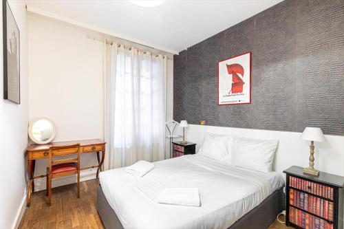 - une chambre dotée d'un lit blanc, d'un bureau et d'un lit sidx sidx sidx dans l'établissement GuestReady - Hidden Gem with Private Courtyard, à Paris