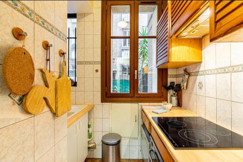 une cuisine avec une cuisinière et une fenêtre dans l'établissement GuestReady - Hidden Gem with Private Courtyard, à Paris