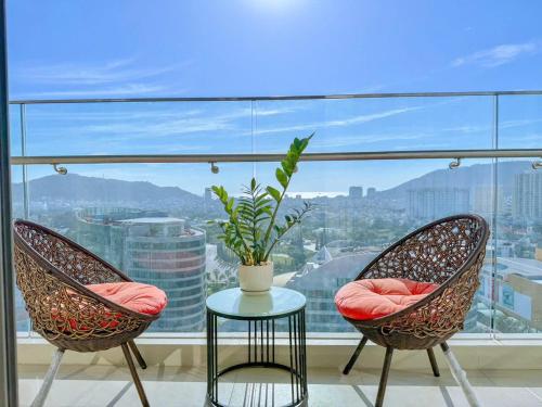 two chairs and a table in front of a window at Monica Homestay - Căn hộ The Song Vũng Tàu in Vung Tau