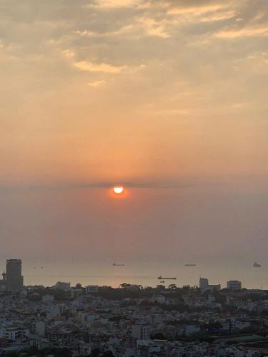 a view of the sun setting over a city at Monica Homestay - Căn hộ The Song Vũng Tàu in Vung Tau