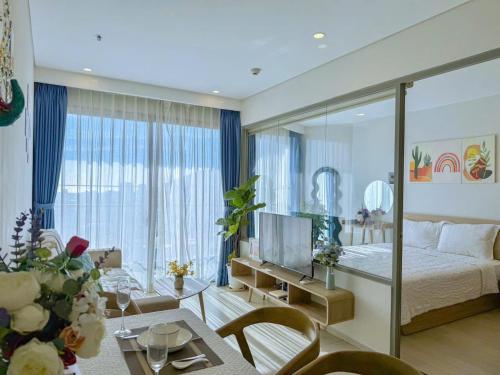 a bedroom with a bed and a living room at Monica Homestay - Căn hộ The Song Vũng Tàu in Vung Tau