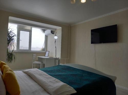 une chambre avec un lit avec une télévision au mur dans l'établissement Космос-Лайт, à Aqtöbe