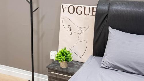 a bedroom with a bed with a plant on a night stand at Sunset Haven Taiping Homestay near Lake Garden TPG in Taiping