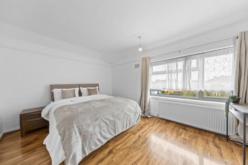 a white bedroom with a bed and a window at Large 4BR Leicester House, Modern, Sleeps 10, M1&M69, Garden, Fast WiFi, Free Secure Parking, Long Stay & Contractors Welcome in Leicester