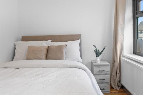 a white bedroom with a white bed and a window at Large 4BR Leicester House, Modern, Sleeps 10, M1&M69, Garden, Fast WiFi, Free Secure Parking, Long Stay & Contractors Welcome in Leicester