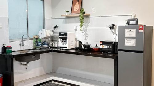 a kitchen with a counter top and a refrigerator at Sunset Haven Taiping Homestay near Lake Garden TPG in Taiping