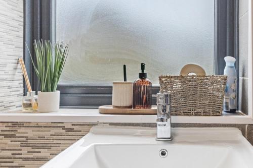a white sink in a bathroom with a window at Large 4BR Leicester House, Modern, Sleeps 10, M1&M69, Garden, Fast WiFi, Free Secure Parking, Long Stay & Contractors Welcome in Leicester