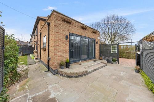 a brick building with a patio in front of it at Large 4BR Leicester House, Modern, Sleeps 10, M1&M69, Garden, Fast WiFi, Free Secure Parking, Long Stay & Contractors Welcome in Leicester