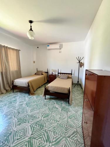 a room with two beds and a carpet at Casa en alquiler temporario in Ramallo