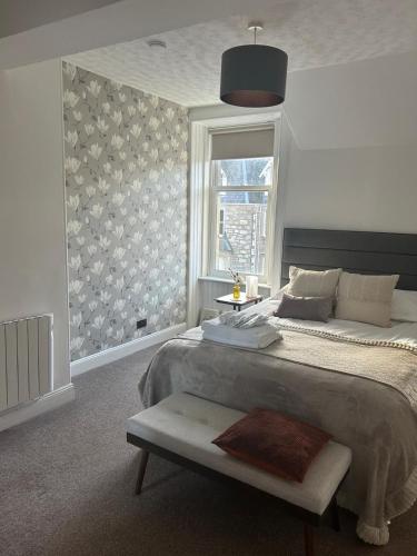 a bedroom with a large bed and a window at Alba Apartment Central Pitlochry in Pitlochry