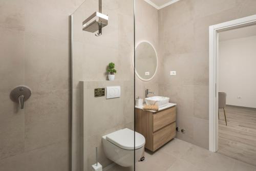 Un baño con inodoro, lavabo y ducha. en Villa Santila, en Labin