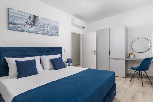 Un dormitorio con una cama azul y blanca y una silla en Villa Santila, en Labin