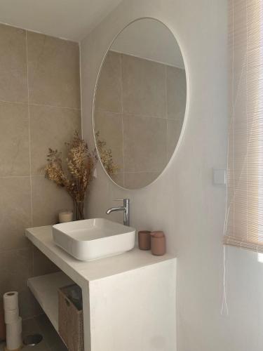 a bathroom with a white sink and a mirror at So Magoito Tiny house in Sintra