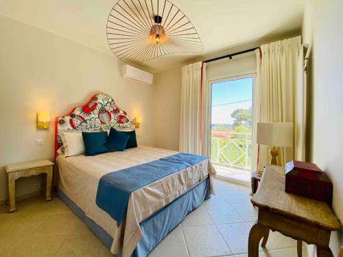 une chambre avec un lit et une grande fenêtre dans l'établissement Villa cap d'antibes, à Antibes
