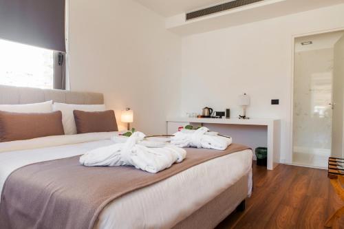 a bedroom with a bed with white towels on it at Andon Lapa Hotel & Spa in Sarandë