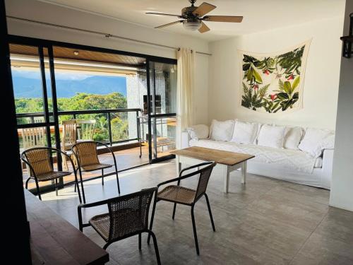 a living room with a couch and a table and chairs at Riviera 200m Praia Serv de Praia and Pisc Aquec in Bertioga