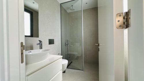 ein weißes Badezimmer mit Waschbecken und Toilette in der Unterkunft Luxury 4 bdr Villa Nerida in Klorakas