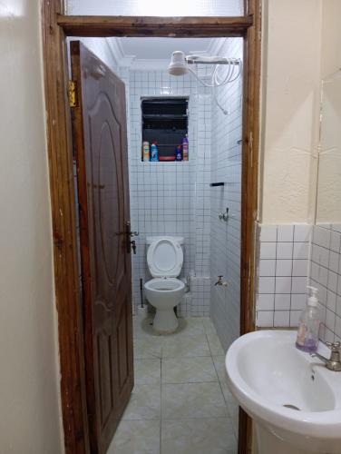 a bathroom with a toilet and a sink at Luxury 1BR - Traven Homes in Ruiru