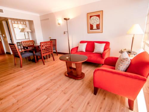 a living room with a red couch and a table at Swissotel Quito in Quito