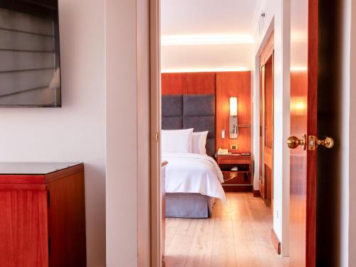 a hotel room with a bed and a hallway at Swissotel Quito in Quito