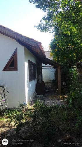 a small white house with a window and a roof at Bangalô Lygia in Florianópolis