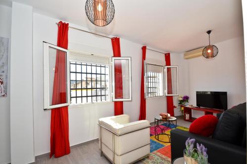 a living room with red curtains and a couch at The Zentral Suites & Apartments in Seville