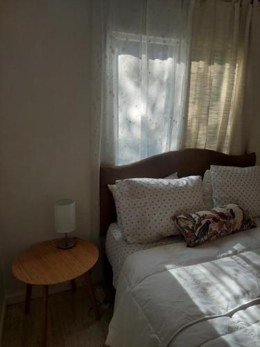 a bedroom with a bed and a table and a window at Punta Horizonte Cabin in San José de Maipo