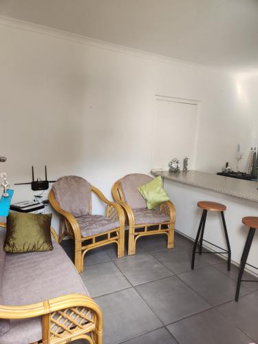 a room with two wicker chairs and a table at HartebeesDen in Worcester