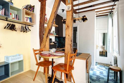 une salle à manger avec une table et des chaises en bois dans l'établissement Ideal pour 2 Appartement Rue Caffarelli, à Paris