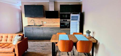 a kitchen with a wooden table and chairs and a kitchen with a kitchen at Oberland-Ferienwohnung-Puerschling-Wurmansau-inkl-Koenigscard in Unterammergau