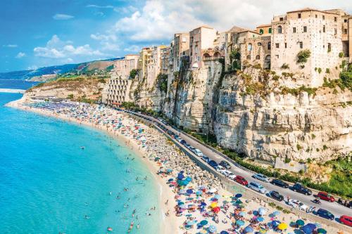 a group of people on a beach with umbrellas at I Soffitti Dimora Esclusiva in Tropea