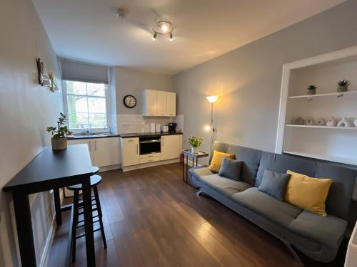 a living room with a couch and a kitchen at Comfortable one-bedroom apartment Free parking space in Edinburgh