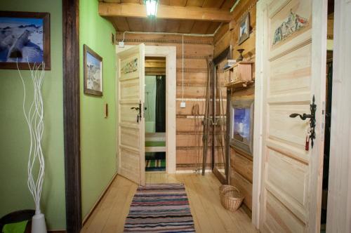 a hallway with green walls and a wooden door at Legenda Tatr in Zakopane