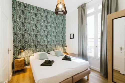 une chambre avec un grand lit blanc avec des serviettes dessus dans l'établissement Magnifique 3 chambres, vue sur le port, clim., à La Ciotat