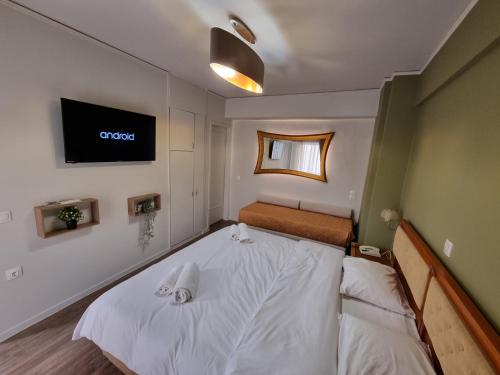 a bedroom with a bed and a tv on the wall at Savoy Hotel in Piraeus