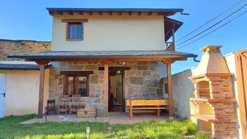 Otero de SanabriaにあるCasa Rural Sanabriaの小さな家(テーブル、ベンチ付)