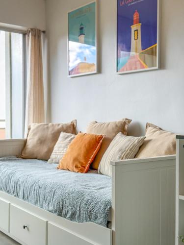 - une chambre avec un lit doté d'oreillers et un phare dans l'établissement La Rose Des Vents - Studio - Arago - Vue mer, à Les Sables-dʼOlonne