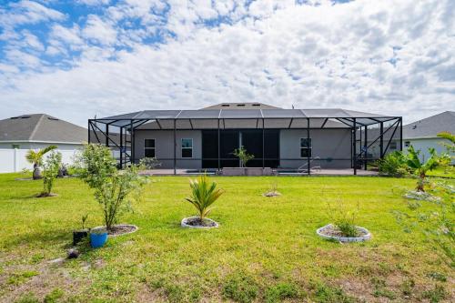 a house with a black roof and some plants in a yard at Heated Pool 4BR Retreat Family Friendly in Carlton