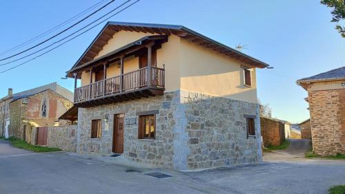 Otero de SanabriaにあるCasa Rural Sanabriaの石造りの家で、バルコニーが付いています。